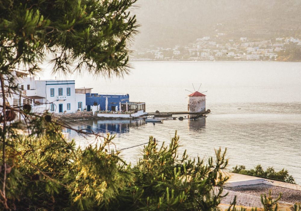 A windmill beside the sea, some houses and a restaurant in Agia Marina, Leros.  Off-The-Beaten-Track Greece Destinations.