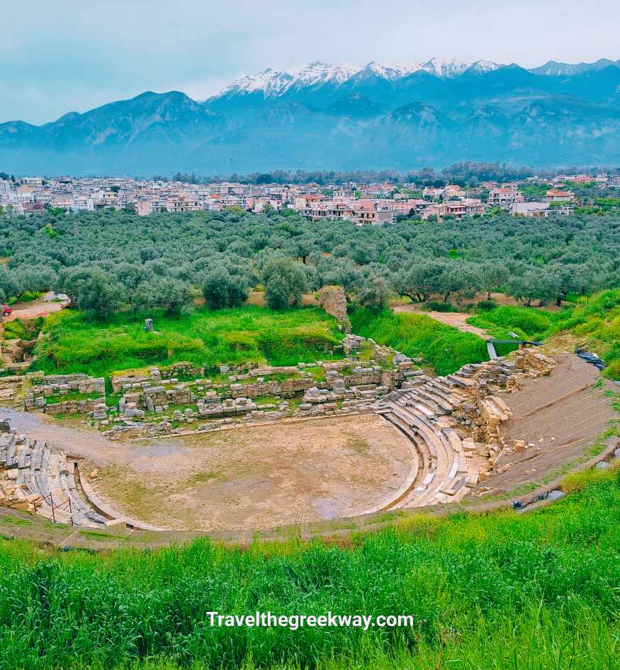 Stone ruins of the Ancient Theater of Sparta looking over olive groves toward snow-capped Taygetos mountains in Peloponnese, Greece.