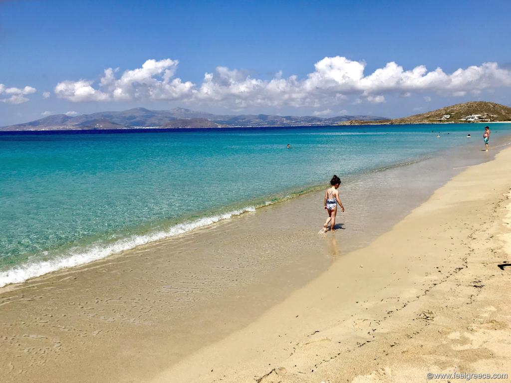 A child walking on the sandy beach of Afios Prokopios in Naxos Greece