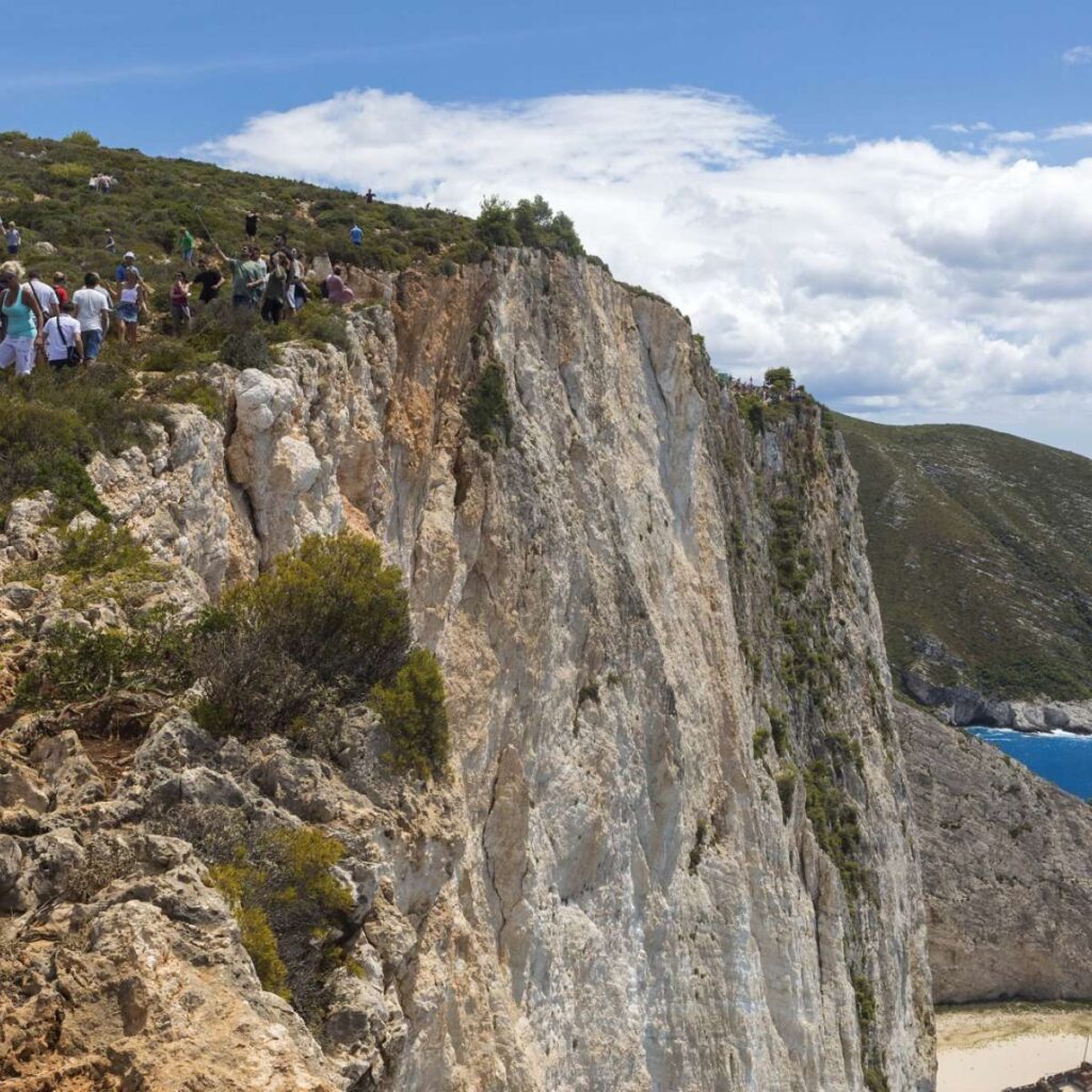 things to do on Zakynthos Island: The cliff at the Navagio Beach with people taking photos