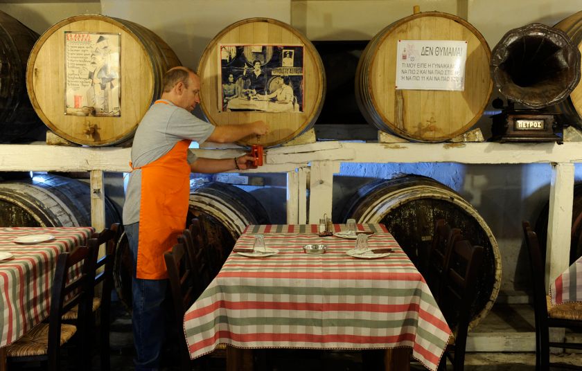 Loukidelis Tavern in Athens, a man pouring wine in a jar from a barrel.