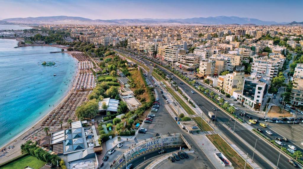 A scenic aerial view of Alimos in the Athens Riviera, featuring a beautiful coastline with a busy beach and urban landscape.