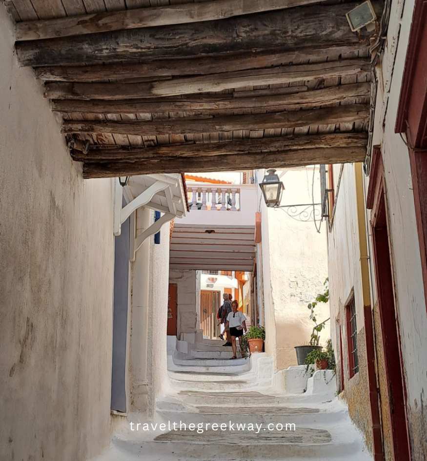 Narrow alley with whitewashed walls and wooden ceiling in Ioulida, showing traditional Cycladic architecture in Kea island, Greece.