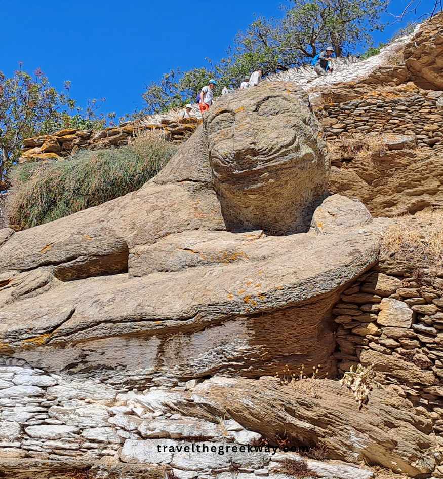 The ancient Lion of Kea island in Greece (Liontas), a massive 6th-century BCE stone-carved monument with its famous "archaic smile" in a rocky landscape.