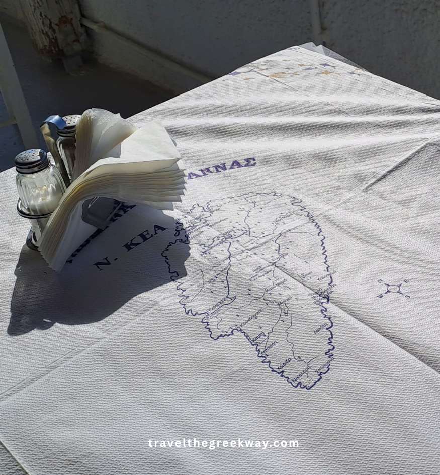 A white paper tablecloth featuring a printed map of Kea island at a local restaurant in the Cyclades, Greece.