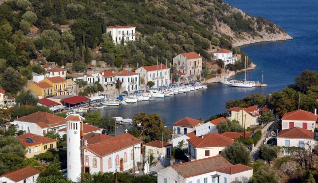 A scenic view of the seaside promenade in Kioni in Ithaca Greece, where locals and visitors enjoy a leisurely stroll along the waterfront, surrounded by cafes, shops, and the timeless beauty of the sea.