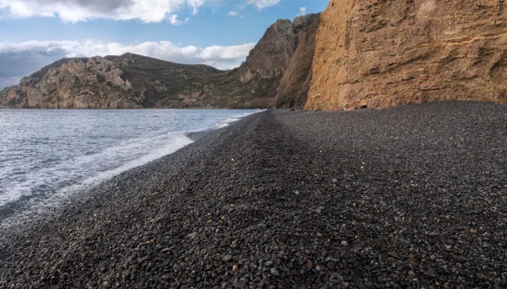 Chios Greece, the black pebbled beach of Mavra Volia with rocky background