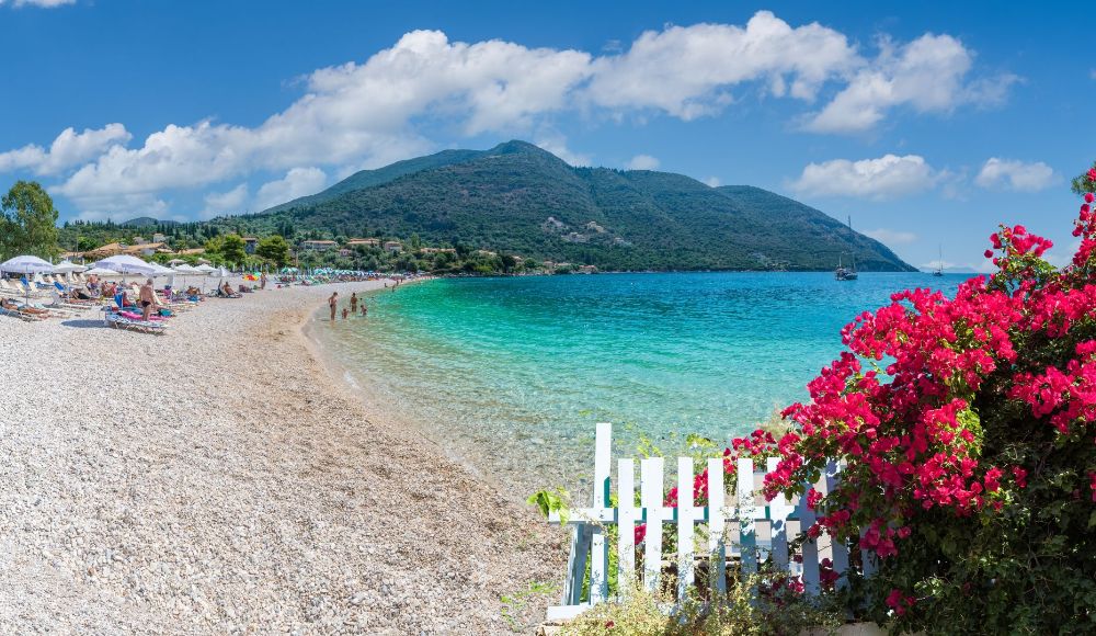 Things to do in Lefkada Greece: Mikros Gilaos beach with light blue waters and people by the beach