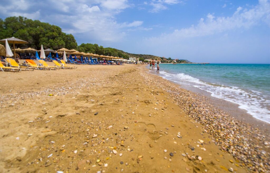 Sandy Komi Beach with swimmers.