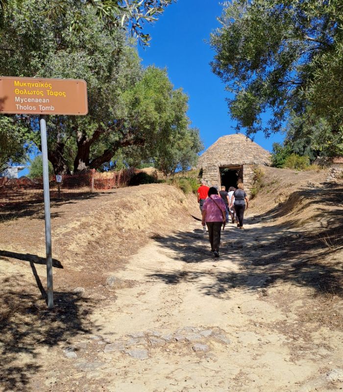 People walking towards the entrance of Tholos tomb at the Palace of Nestor