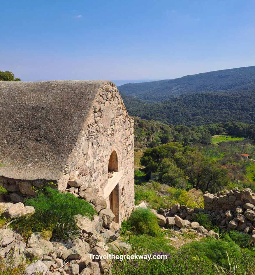 Exterior of an old stone Byzantine church on a hillside overlooking the valley landscape of Aegina Island, Saronic Gulf, Greece.
