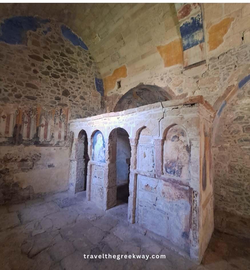 Weathered stone altar and crumbling religious frescoes inside an ancient Byzantine church in Paleachora, Aegina Island, Greece.