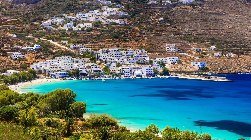 View of whitewashed house on a hill and a beach called Aegiali in Amorgos Island Greece.