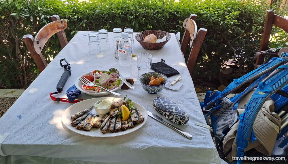 A set table with a Greek salad and sardines. 