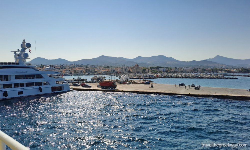 Aegina port with a ferry and cars waiting to get aboard. 