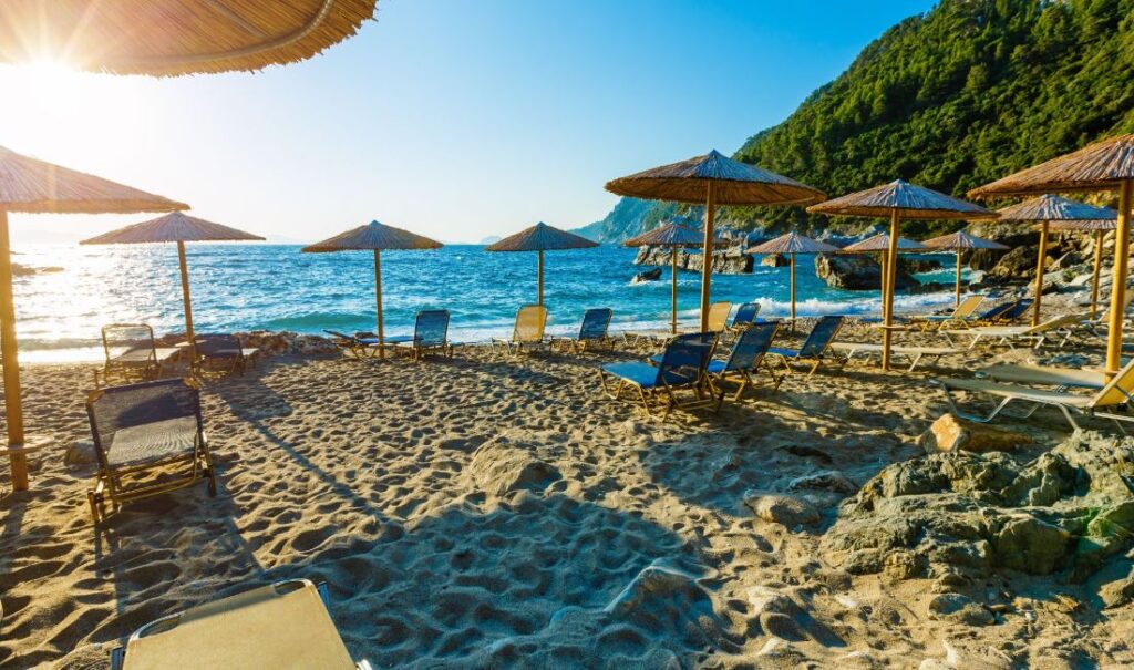 Sandy Agios Ioannis beach with beds and umbrellas, Skopelos Greece