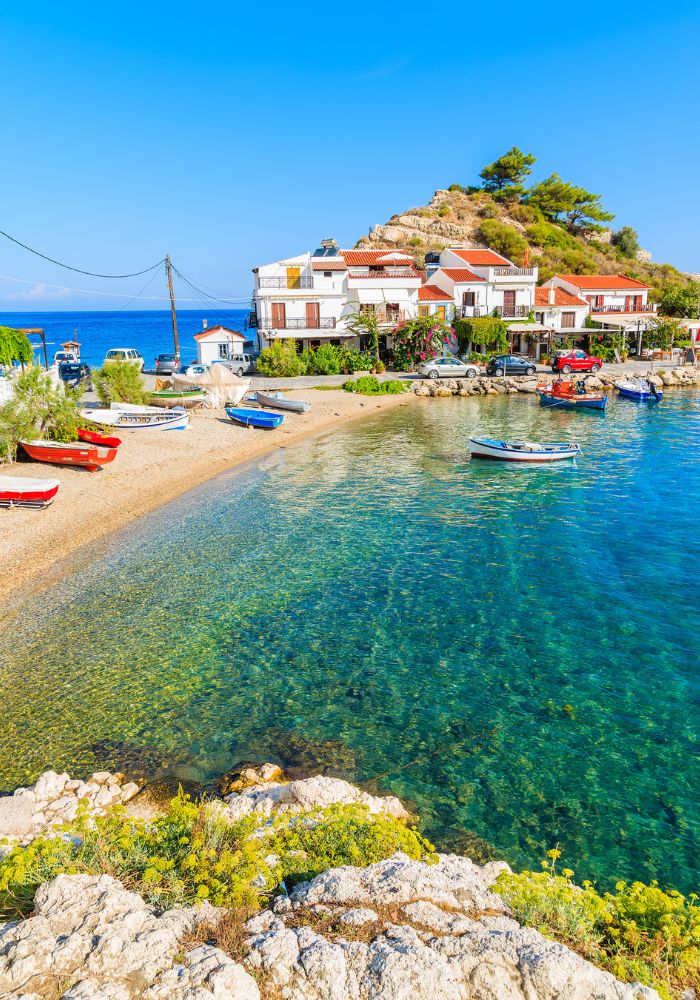 Things to Do in Samos Greece Kokkari beach with blue waters and fishing boats