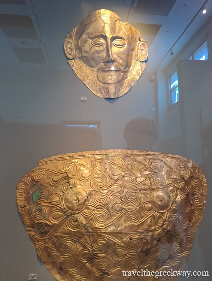 Agamemnon Mask Golden funeral mask and decorative shield from Mycenae, Greece, displayed in a museum.