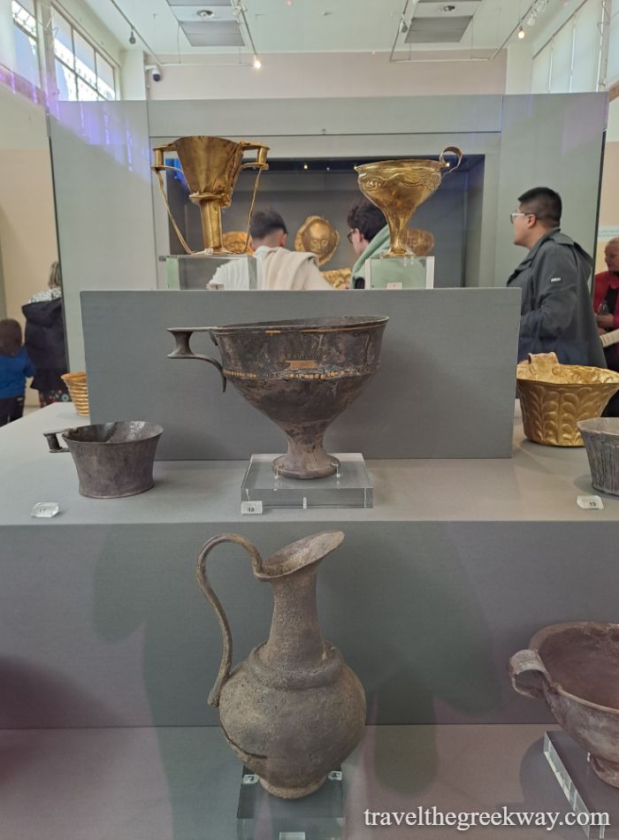 Grave artifacts arranged in shapes from Mycenae’s Grave Circle, displayed in a museum in Greece.