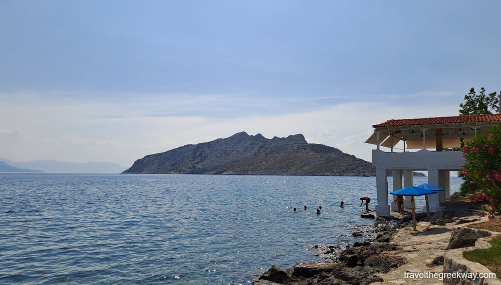 Moni island and the rocky beach where people swim in Aegina. 