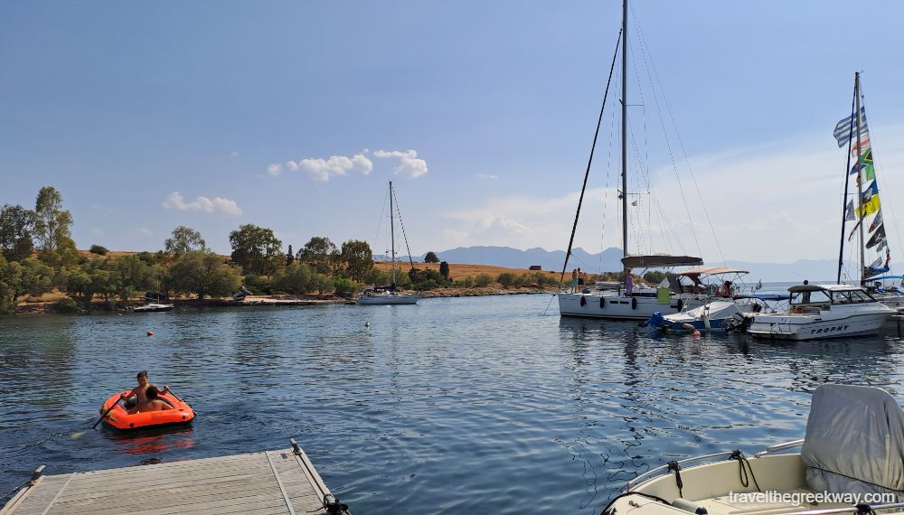 The small port of Perdika with yachts and a small inflatable boat with 2 children. 