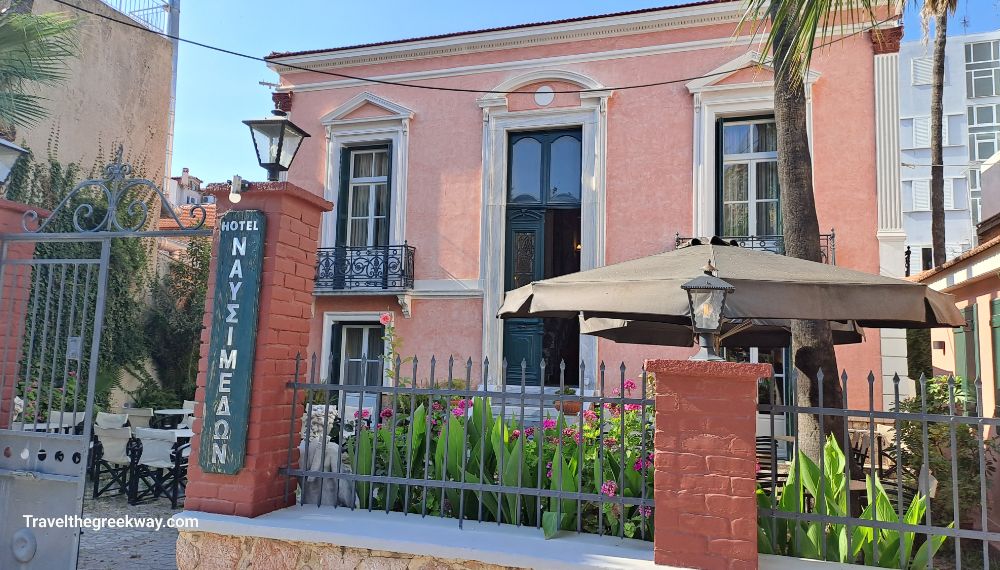 The exterior of Nafsimedon Hotel with a garden and tables. 