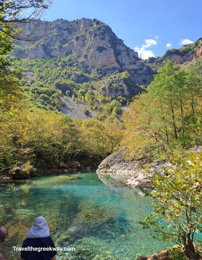 An emerald lake surrounded by high rocks in Vikos gorge in Monodendri Greece. 