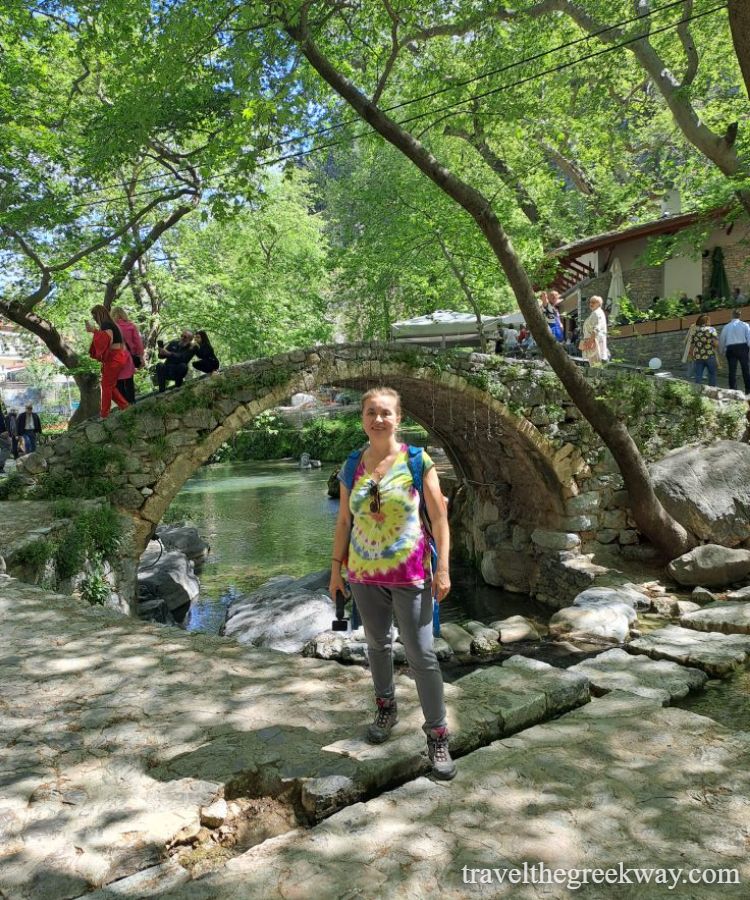 Evgenia in front of a stone bridge in Livadia Greece.