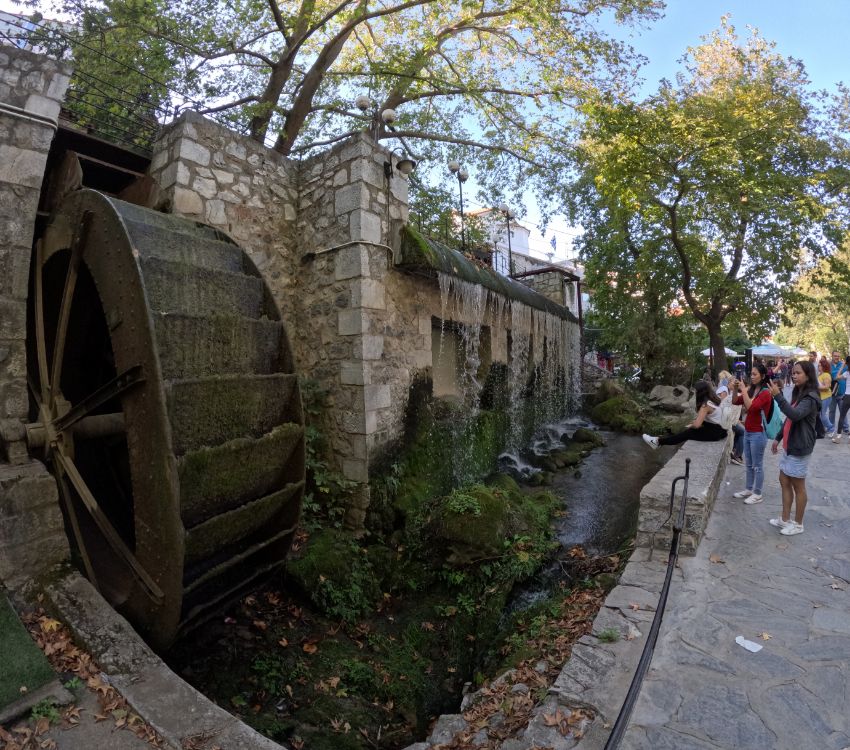 Tourists taking photos of a watermill in Livadia, mainland Greece. 