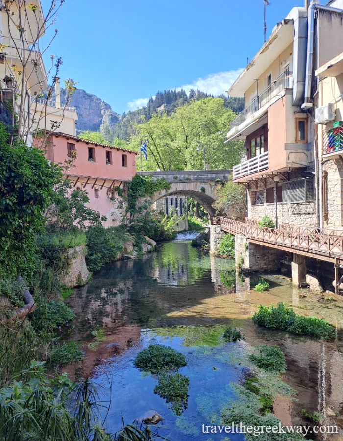 Scenic view of the river running between old stone houses and bridges in Livadia’s charming old town.