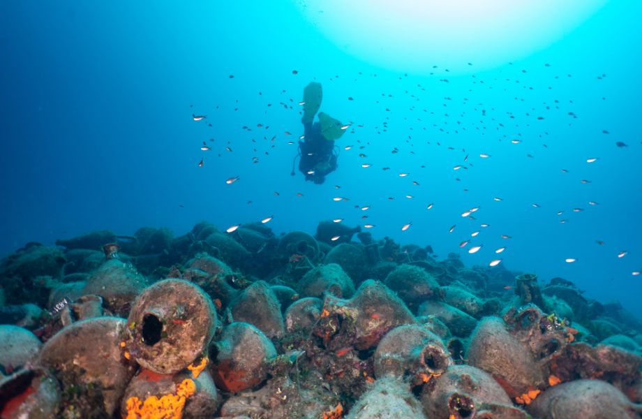 A diver swimming around ancient vessels in Sporades. 