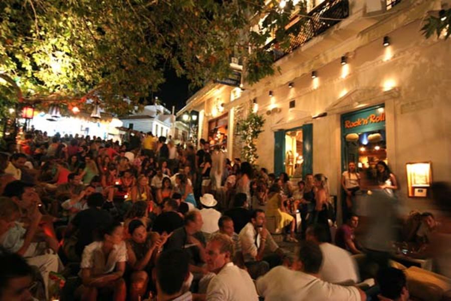 People at a party in a yard of a bar in Skiathos. 