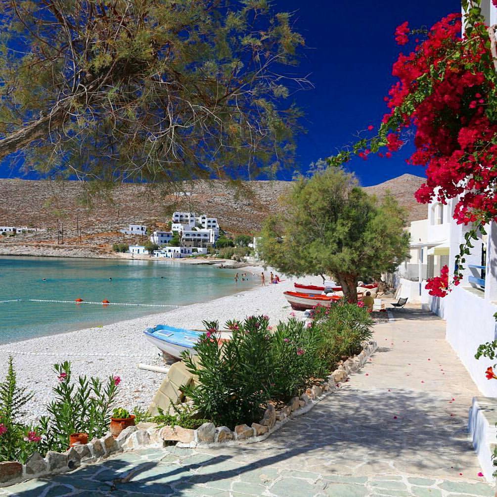 Karavostasis port in Folegandros with red flowers and whitewashed houses. 