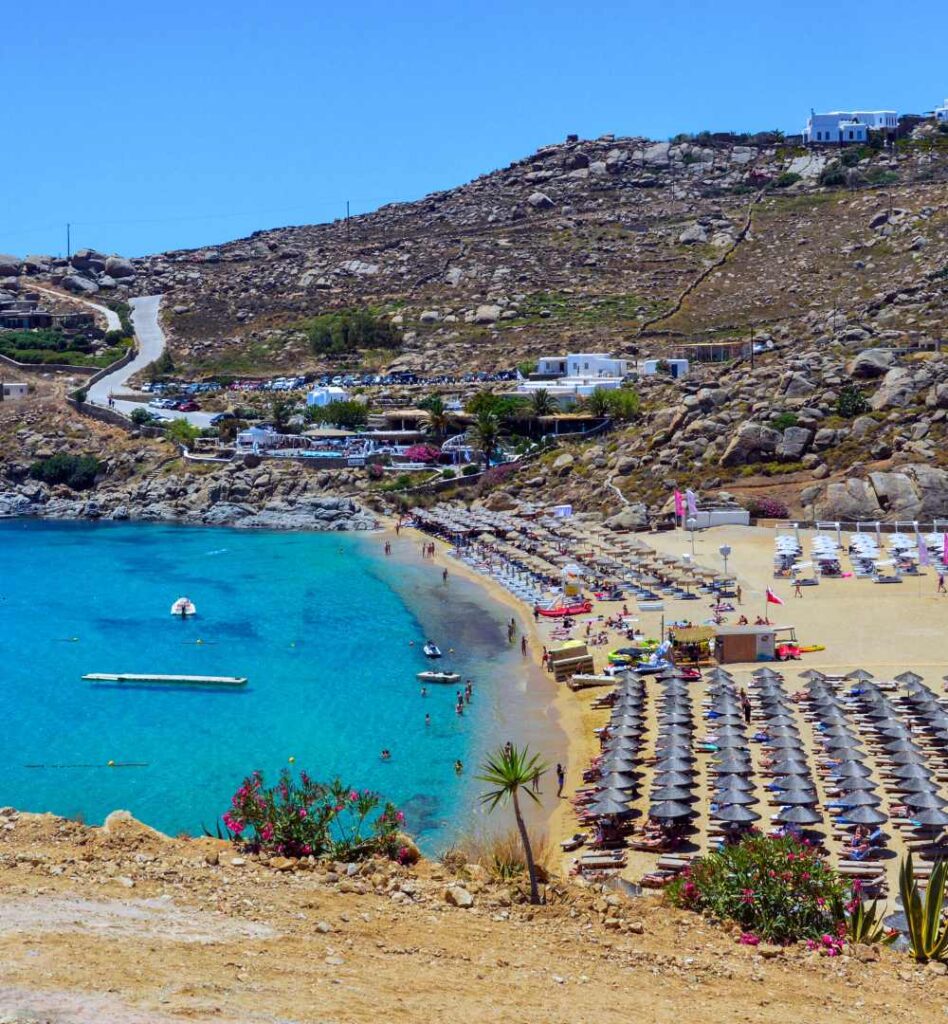 Paradise Beach in Mykonos with shallow blue water and lively beach atmosphere.