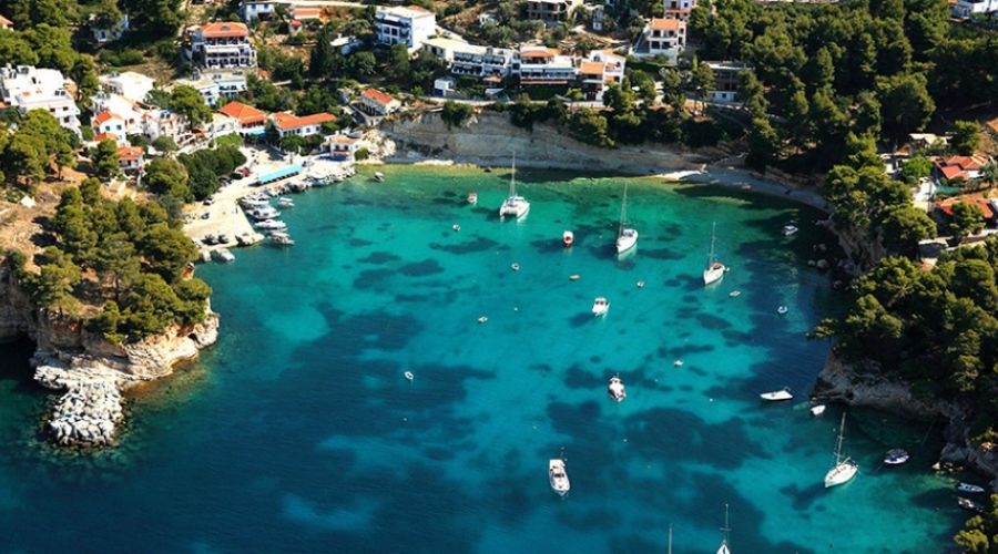An idyllic seafront hamlet on Alonissos Island, characterized by its picturesque harbor dotted with fishing vessels and sailboats.
