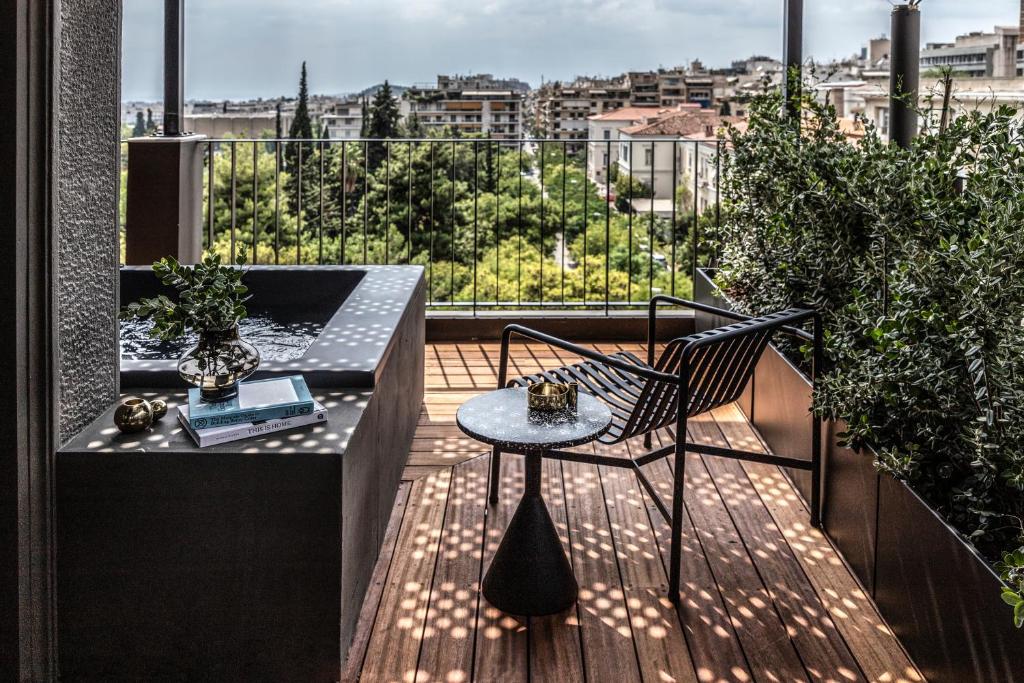 A stylish balcony at The Modernist Hotel in Athens, featuring modern design elements and overlooking the lush greenery of the city.