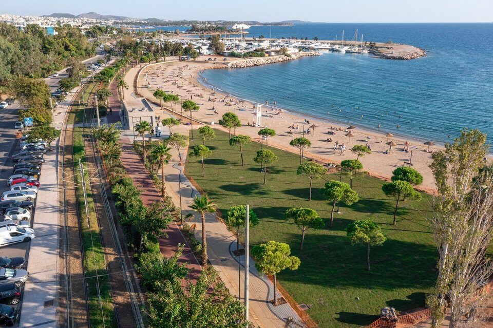 Aerial view of Glyfada Beach in Athens Riviera, featuring a sandy beach, green spaces, and a picturesque coastline.