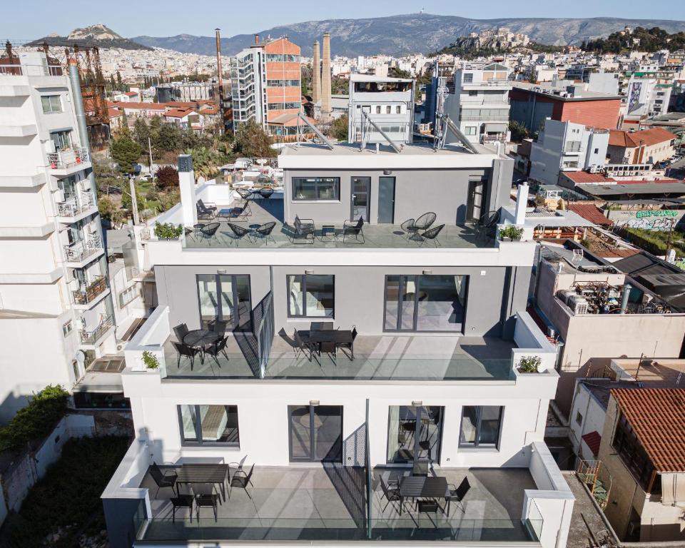 Modern apartment building in Athens with large balconies and views of the city and mountains in the background.