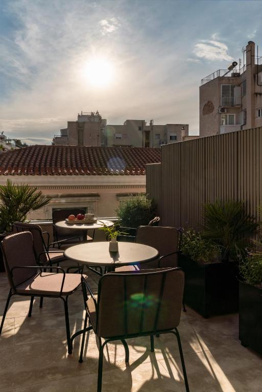 A serene terrace in the Makrygianni neighborhood, offering comfortable seating and a view of the surrounding rooftops at sunset.