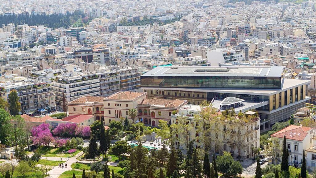 Aerial view of the Makrygianni neighborhood in Athens, featuring the Acropolis Museum surrounded by historic and modern buildings.