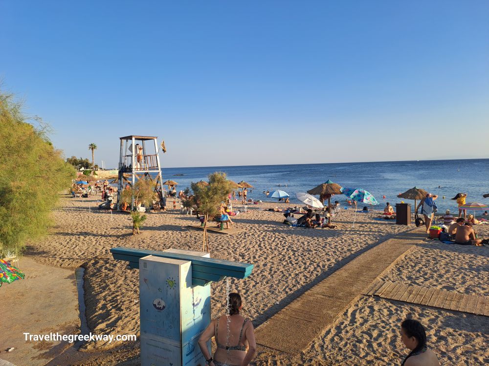 Faliro Beach scene with a lifeguard tower and beachgoers relaxing by the sea.