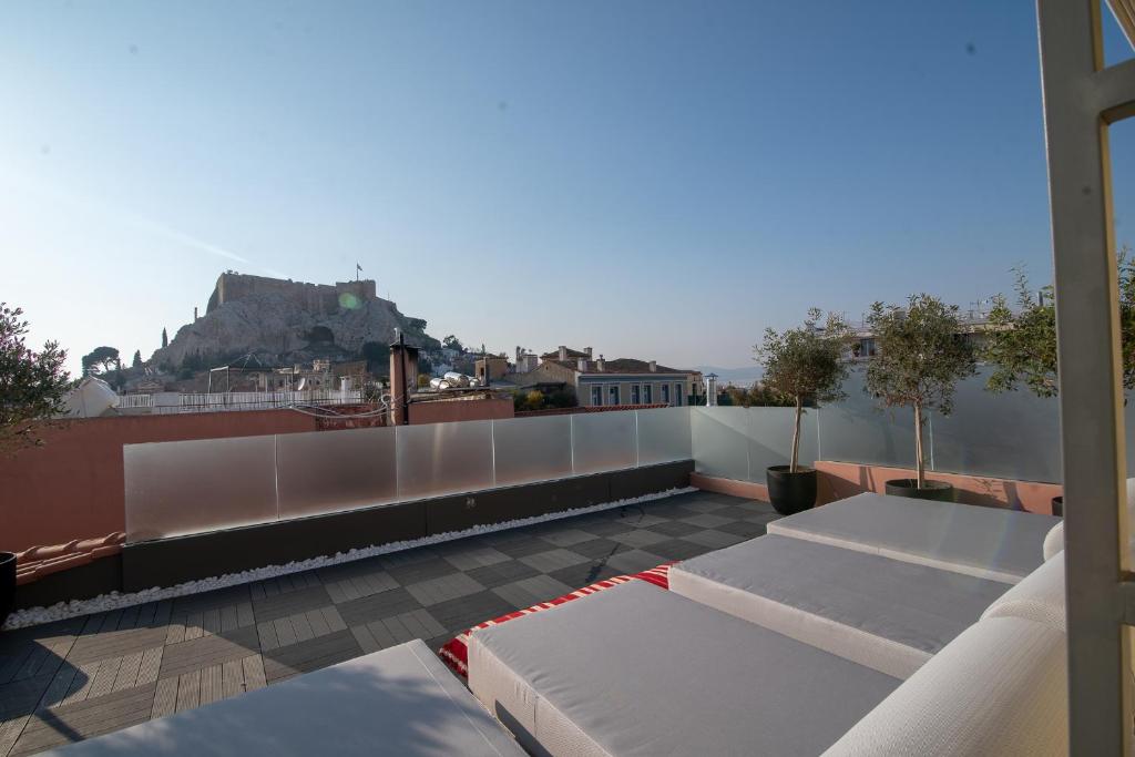 The elegant exterior of the Farmaki Residence Hotel in Plaka, Athens, with a neoclassical design and surrounding greenery.