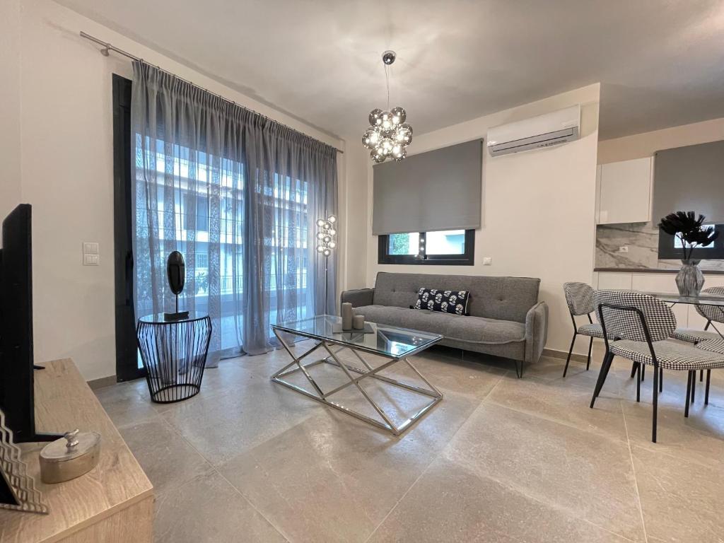 Modern living room in an apartment in Paleo Faliro, with a gray sofa and a glass coffee table.