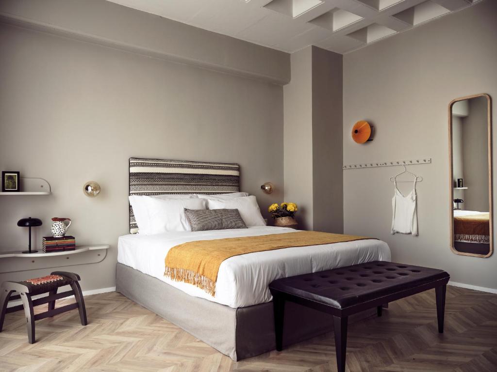 A stylish hotel room with modern decor, featuring a comfortable bed and warm lighting.