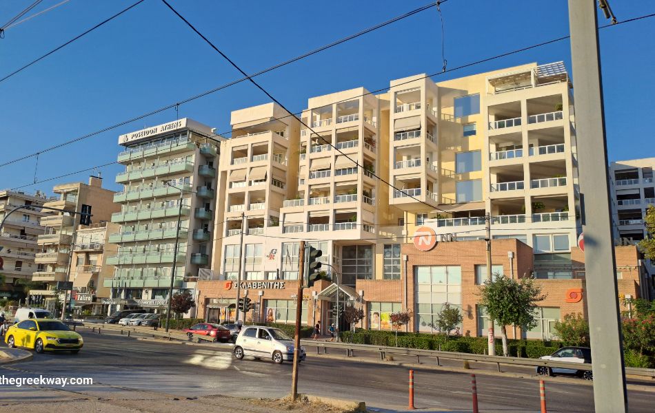 Street view of Poseidon Athens Hotel in Paleo Faliro with cars passing by.