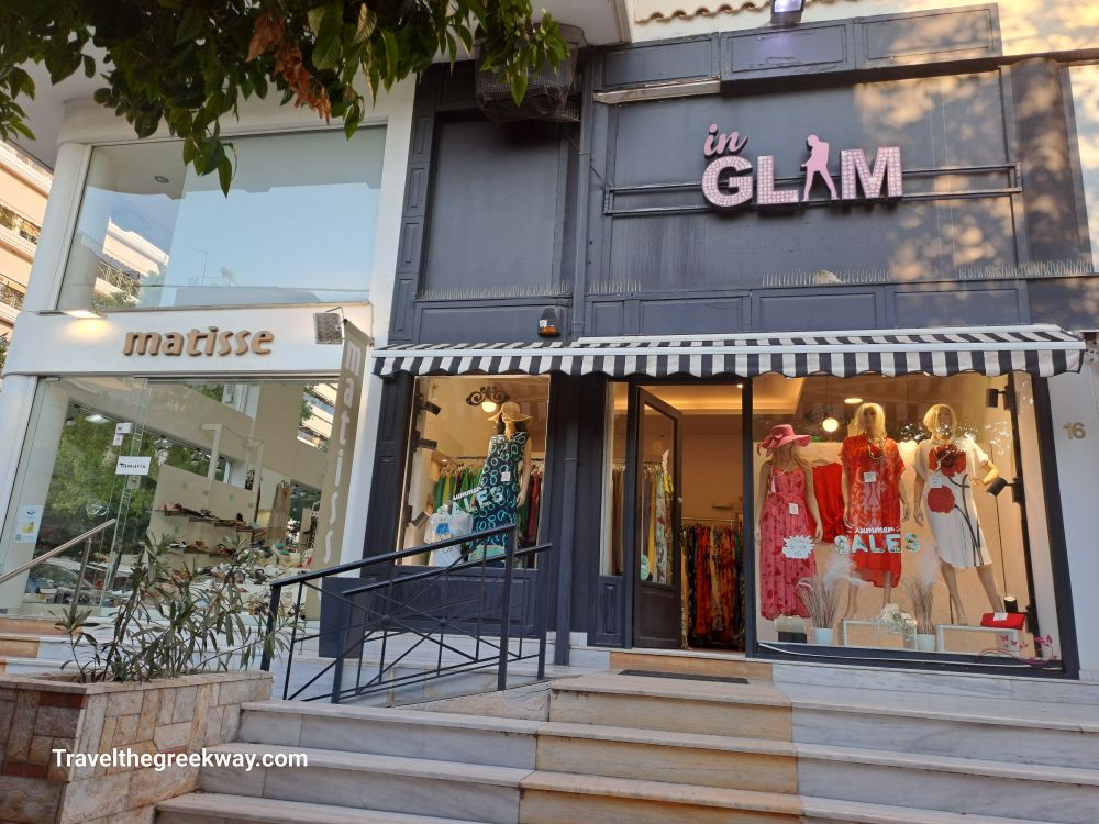 Fashion boutiques "Matisse" and "In Glam" with storefront displays on a shopping street in Paleo Faliro.