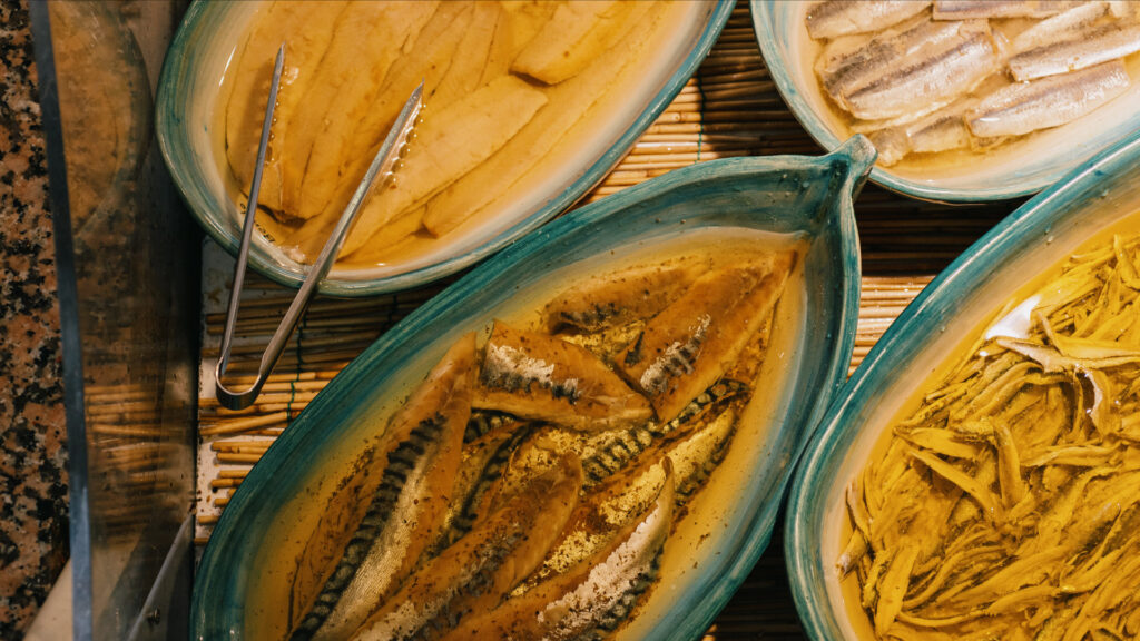 Close-up of marinated fish dishes in ceramic bowls at a restaurant in Paleo Faliro.