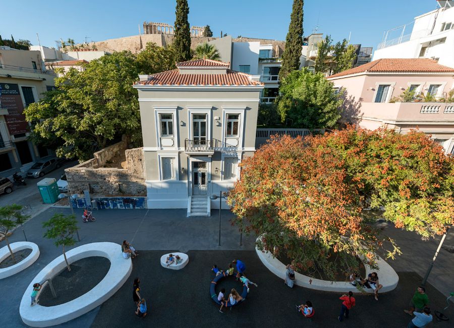 A quiet street in the Makrygianni neighborhood of Athens, featuring neoclassical buildings and a view of the Acropolis.