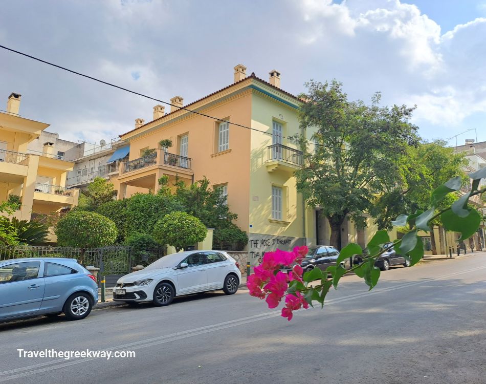 An elegant house in Athens with blooming bougainvillea flowers in the foreground.