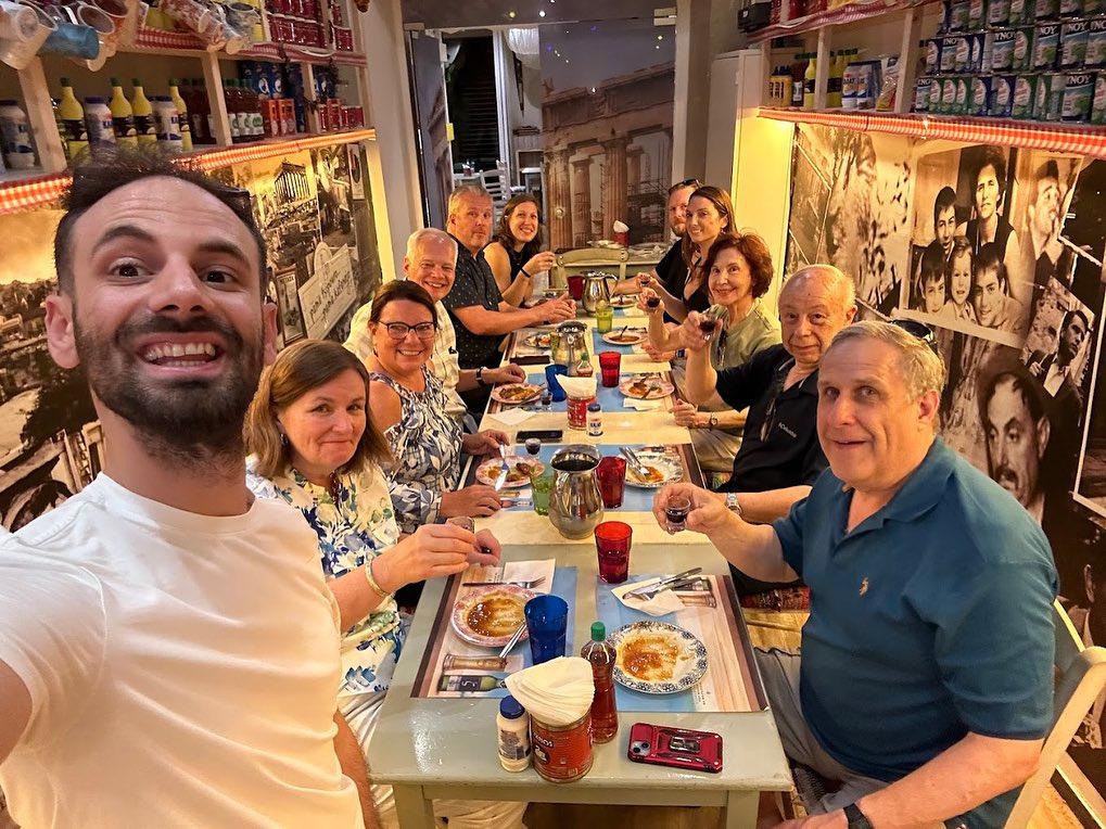 Group of friends enjoying a traditional Greek meal together in a lively and cozy Athens restaurant.